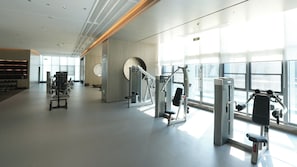 A spacious gym with various exercise machines, large windows, and a modern interior design. - Holiday Inn Express Qidong Economic Zone by IHG (Nantong)