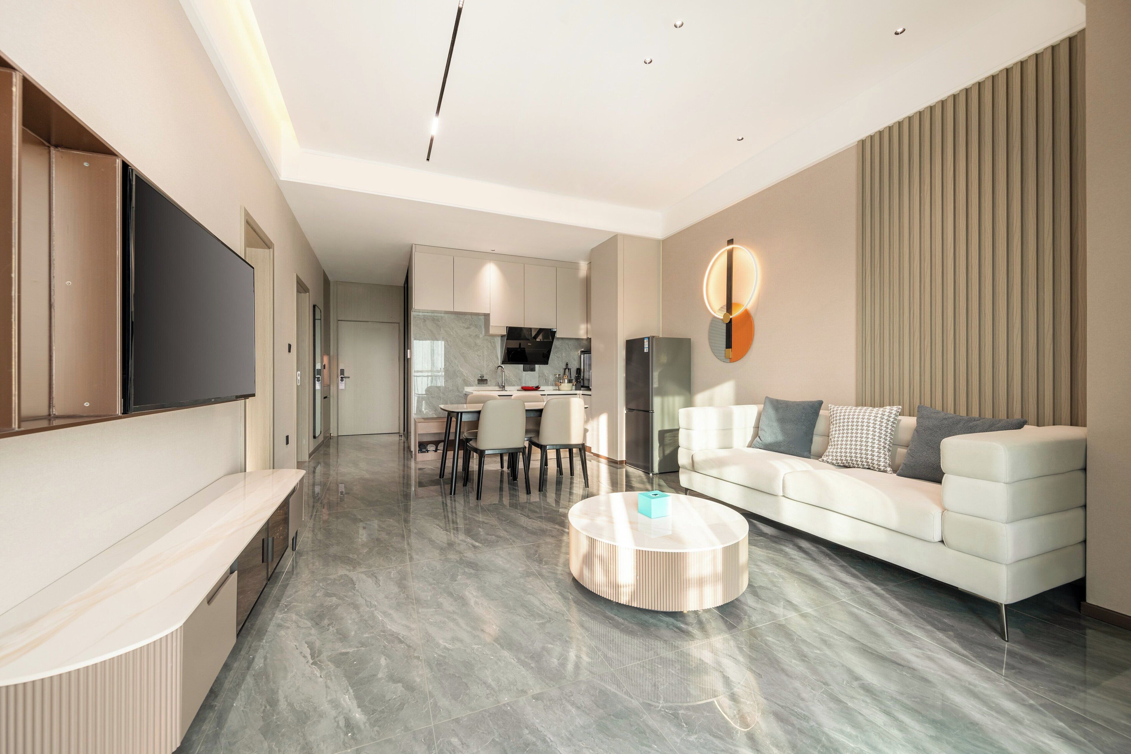 A modern living room with a sofa, a coffee table, and a TV mounted on the wall.