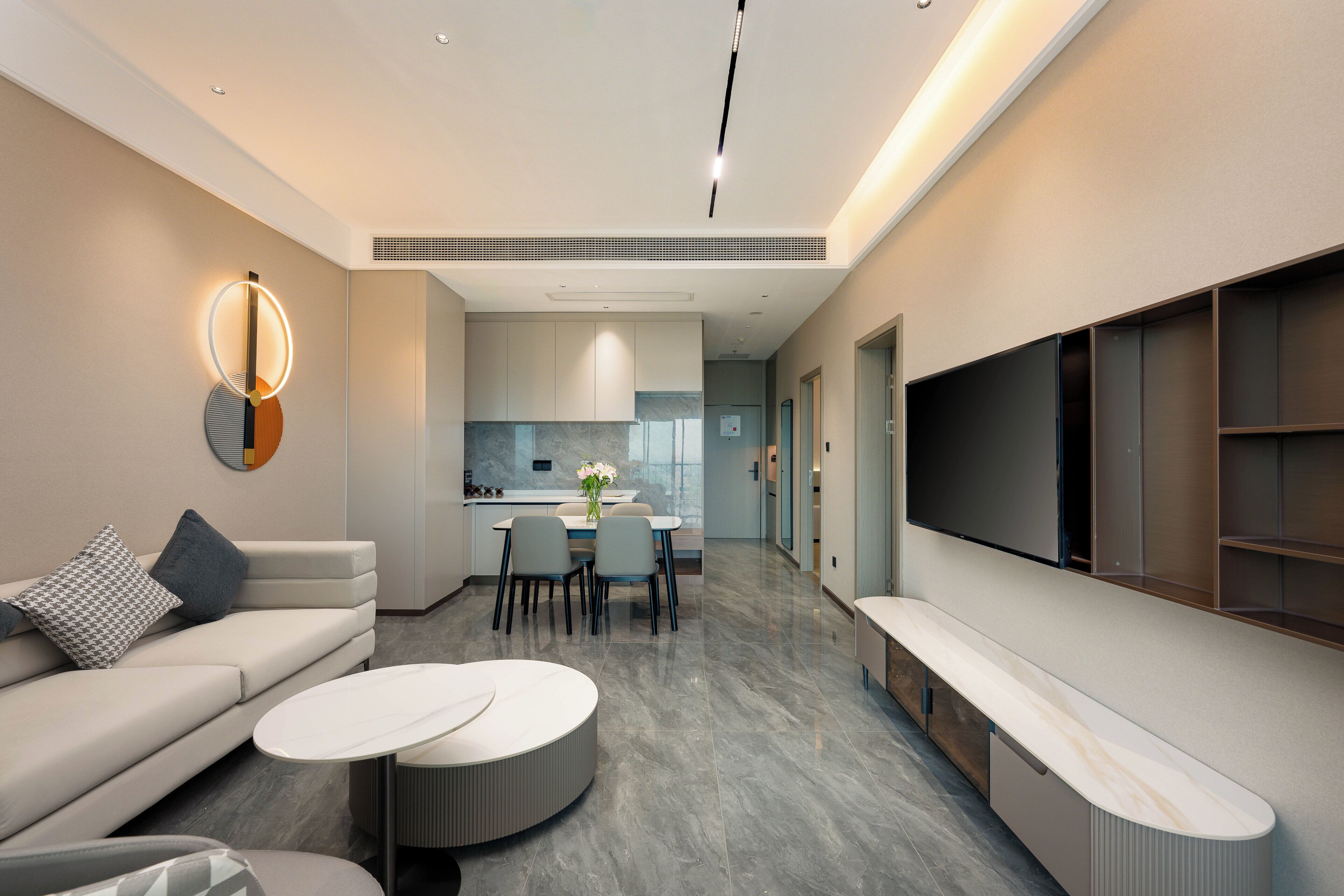 A modern living room with a sofa, coffee table, and TV wall unit.