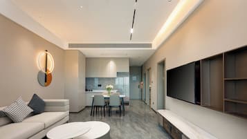 A modern living room with a sofa, coffee table, and TV wall unit.