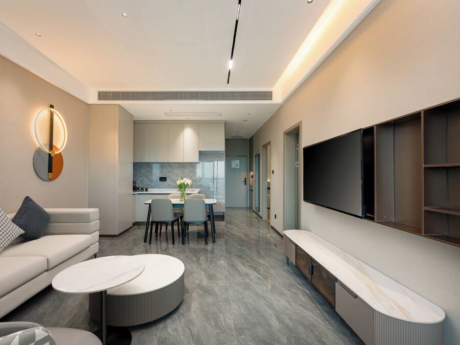 Una sala de estar moderna con sofá, mesa de centro y mueble para la televisión.