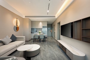 Una sala de estar moderna con sofá, mesa de centro y mueble para la televisión.