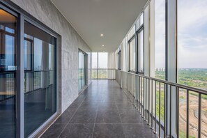 A corridor with large windows and a balcony with a metal railing. - Holiday Inn Express Qidong Economic Zone by IHG (Nantong)