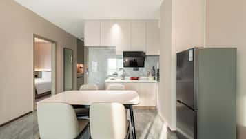 Eine moderne Küche mit Kochinsel, Kühlschrank und Essbereich mit Stühlen.