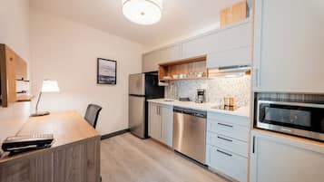A modern kitchen with stainless steel appliances, a wooden countertop, and a built-in oven.
