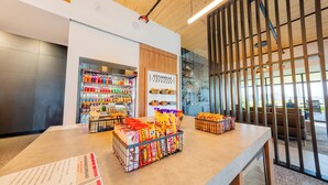A modern interior with a wooden ceiling, a beverage display, and a seating area with a view.