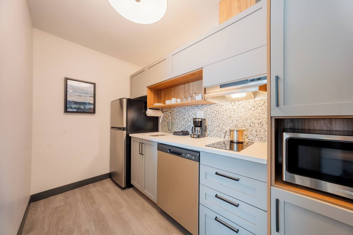 Una cocina moderna equipada con lavavajillas, cafetera y microondas.