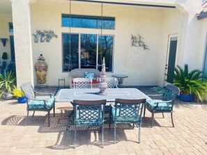 An outdoor patio with a table and chairs, a decorative vase, and potted plants. - GORGEOUS Green Valley AZ house & pool in QC GolfResortSUMMER MONTHLY RENTAL ONLY (Green Valley)