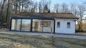 A modern house with large glass windows, a tiled roof, and a gravel driveway. - Nature Retreat by the Lakes (Florennes)