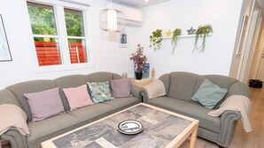 A living room with two grey sofas, a coffee table, and a window with a view of greenery. - 6 Person Holiday Home in Struer (Struer)