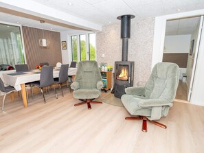 Una sala de estar moderna con chimenea, comedor y zona de estar.