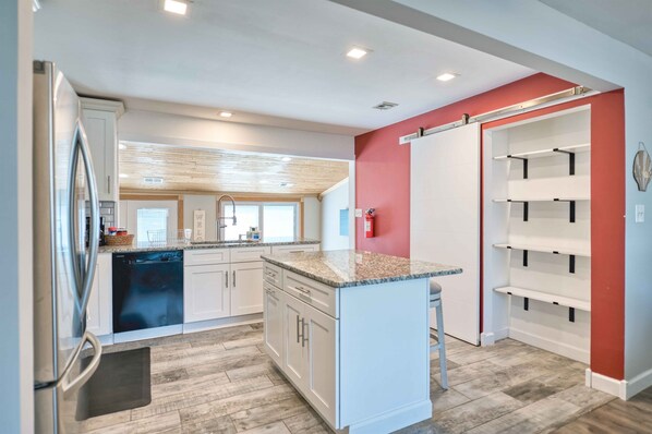 A modern kitchen with white cabinets, granite countertops, and a built-in dishwasher. - Waterfront oasis | 3BR | Game Room | Pet Friendly (Little Egg Harbor)