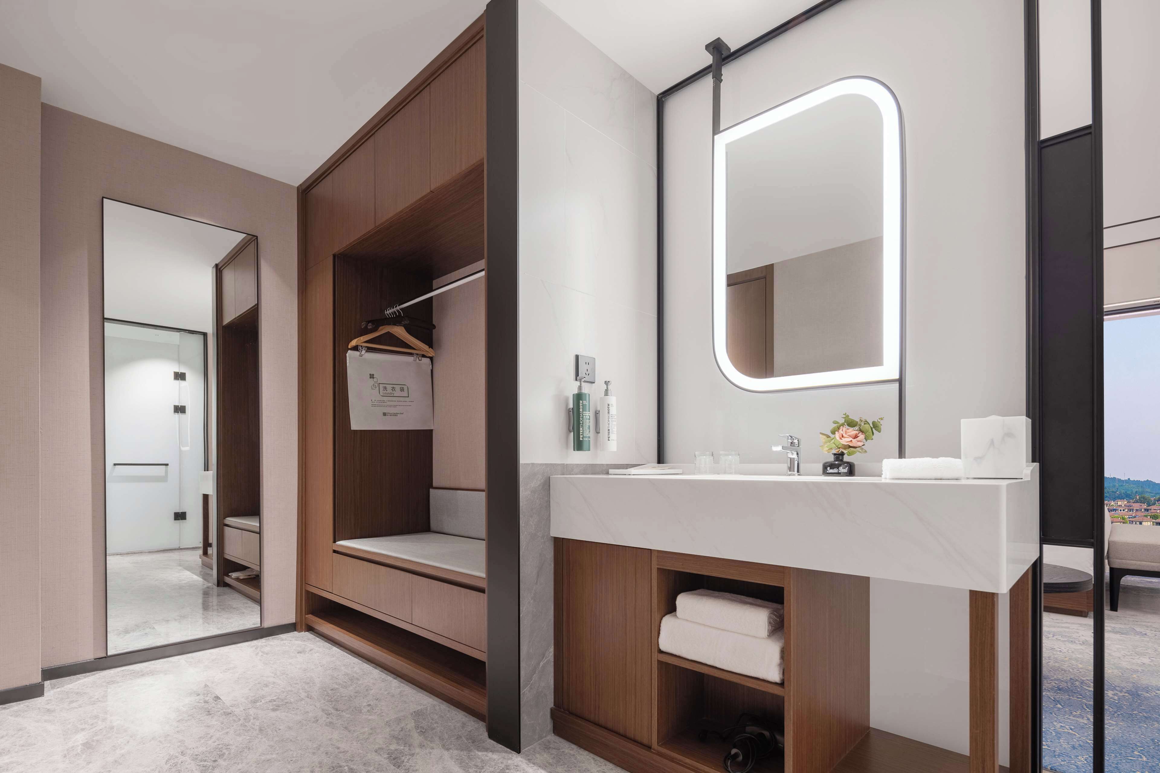 A modern bathroom with a vanity, mirror, and built-in shelves.