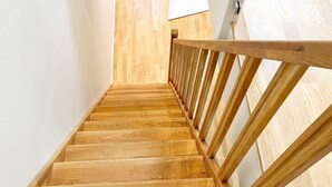 A wooden staircase with a handrail leading to a landing. - 5 Person Holiday Home in Munso (Munsö)