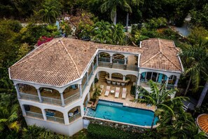 A multi-story house with a swimming pool, surrounded by lush greenery and palm trees. - Villa Romance Free Concierge services (Cruz Bay)