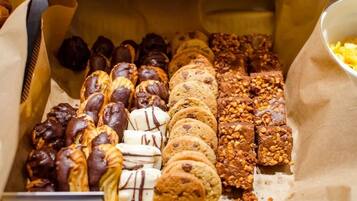 A variety of baked goods including chocolate-covered pastries, cookies, and nut-topped treats.
