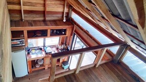 A wooden interior with a kitchen area, including a sink, cabinets, and a refrigerator. - Chale das Torres (Belém)