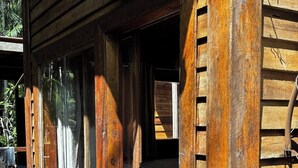A wooden building with a sign reading "ELITE TOURS" and a wooden door with a curtain. - Chale das Torres (Belém)