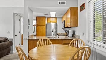 Una cocina moderna con armarios de madera, un refrigerador de acero inoxidable y una encimera de granito.