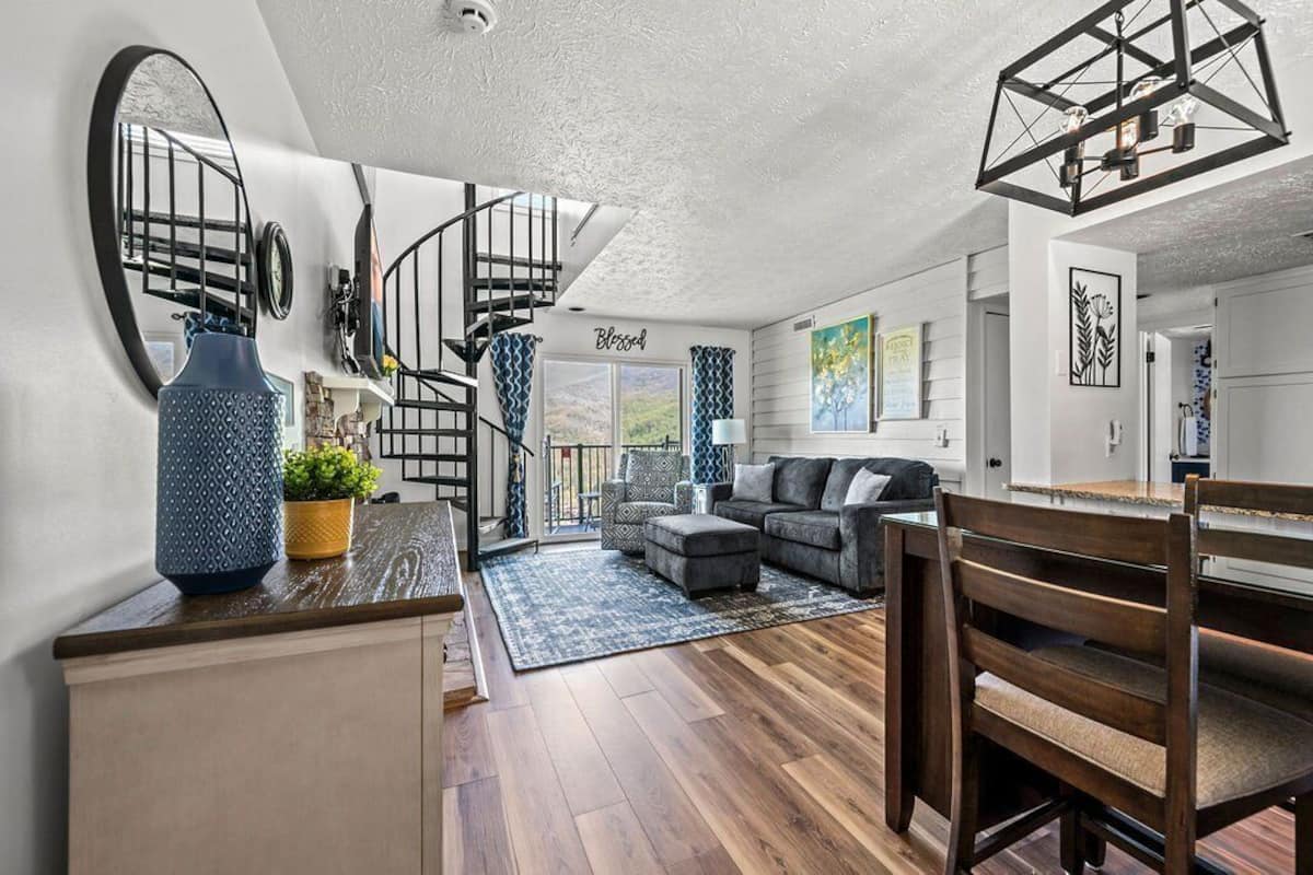 Ein modernes Wohnzimmer mit Treppe, Essbereich und Küche.