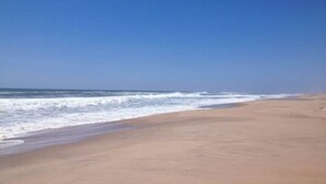 A beach with a clear sky and waves approaching the shore. - Cozy Hamptons Beach House 1 Block from the Beach!  (Montauk)