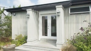 A white building with a front door, steps, and potted plants. - Cozy Hamptons Beach House 1 Block from the Beach!  (Montauk)