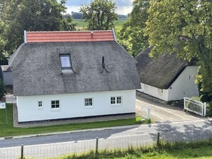 A traditional thatched-roof house with a small window and a chimney. - Hygge-huus-burhave Comfortable Holiday Residence (Butjadingen)