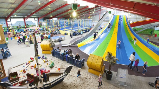 An indoor amusement park with a large slide, sand play area, and a boat ride. - Hygge-huus-burhave Comfortable Holiday Residence (Butjadingen)