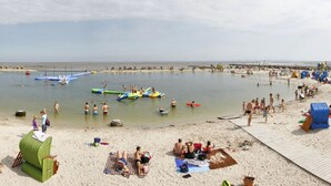 A beach with people sunbathing and swimming. - Hygge-huus-burhave Comfortable Holiday Residence (Butjadingen)