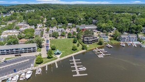 An aerial view of a lakeside town with a marina, buildings, and a parking lot.