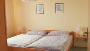 Un dormitorio con una cama de madera, dos lámparas de noche y una luz en el techo.