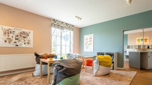A child's playroom with a large window, a radiator, and a colorful bean bag. - Comfy Apartment With Terrace (Dranske)