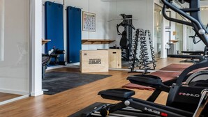 A home gym with a treadmill, weight bench, and various exercise equipment. - Comfy Apartment With Terrace (Dranske)