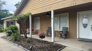 A house with a porch, a swing, and a door with a number.