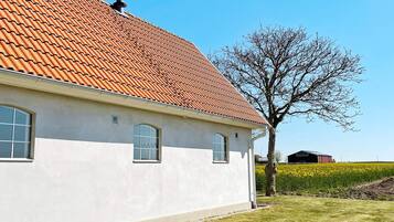 A white building with a tiled roof and a clear sky.