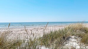 A beach with sand and sparse vegetation in the foreground. - 4 Star Holiday Home in Skivarp (Skivarp)