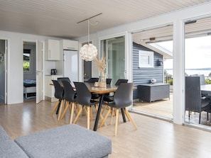A modern interior with a dining area, a sofa, and a view of the outdoors. - 8 Person Holiday Home in Aabenraa (Aabenraa)