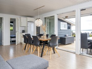 A modern interior with a dining area, a sofa, and a view of the outdoors. - 8 Person Holiday Home in Aabenraa (Aabenraa)