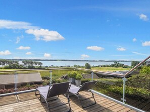 A deck with two chairs overlooking a lake and distant landscape. - 8 Person Holiday Home in Aabenraa (Aabenraa)