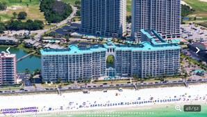 A large hotel complex with multiple high-rise buildings, a central courtyard, and a beachfront location. - Beach Lovers Dream- 2 BR Majestic Sun Condo Sleeps 8! (Destin)