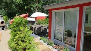 A patio area with outdoor furniture, a grill, and a small shed. - "min Hus" Quiet and Close to the Beach (Zingst)