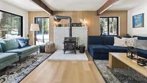 A cozy living room with a fireplace, a sofa, a coffee table, and a lamp.