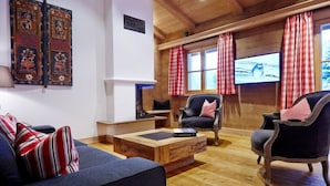 A cozy living room with a fireplace, wooden flooring, and a television. - Suite Birch Modern Retreat (Bad Wiessee)
