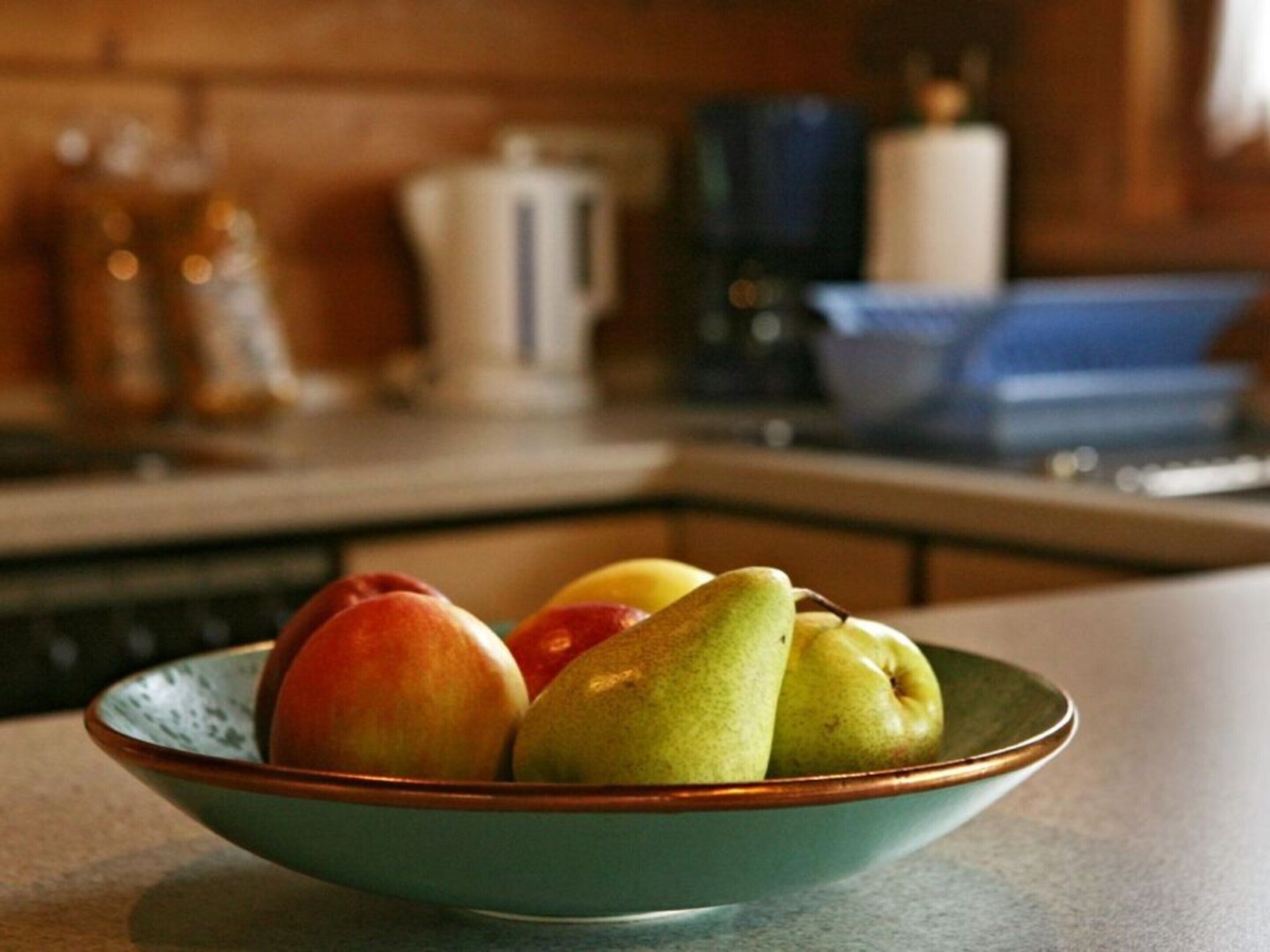 Un saladier de fruits sur un plan de travail de cuisine.