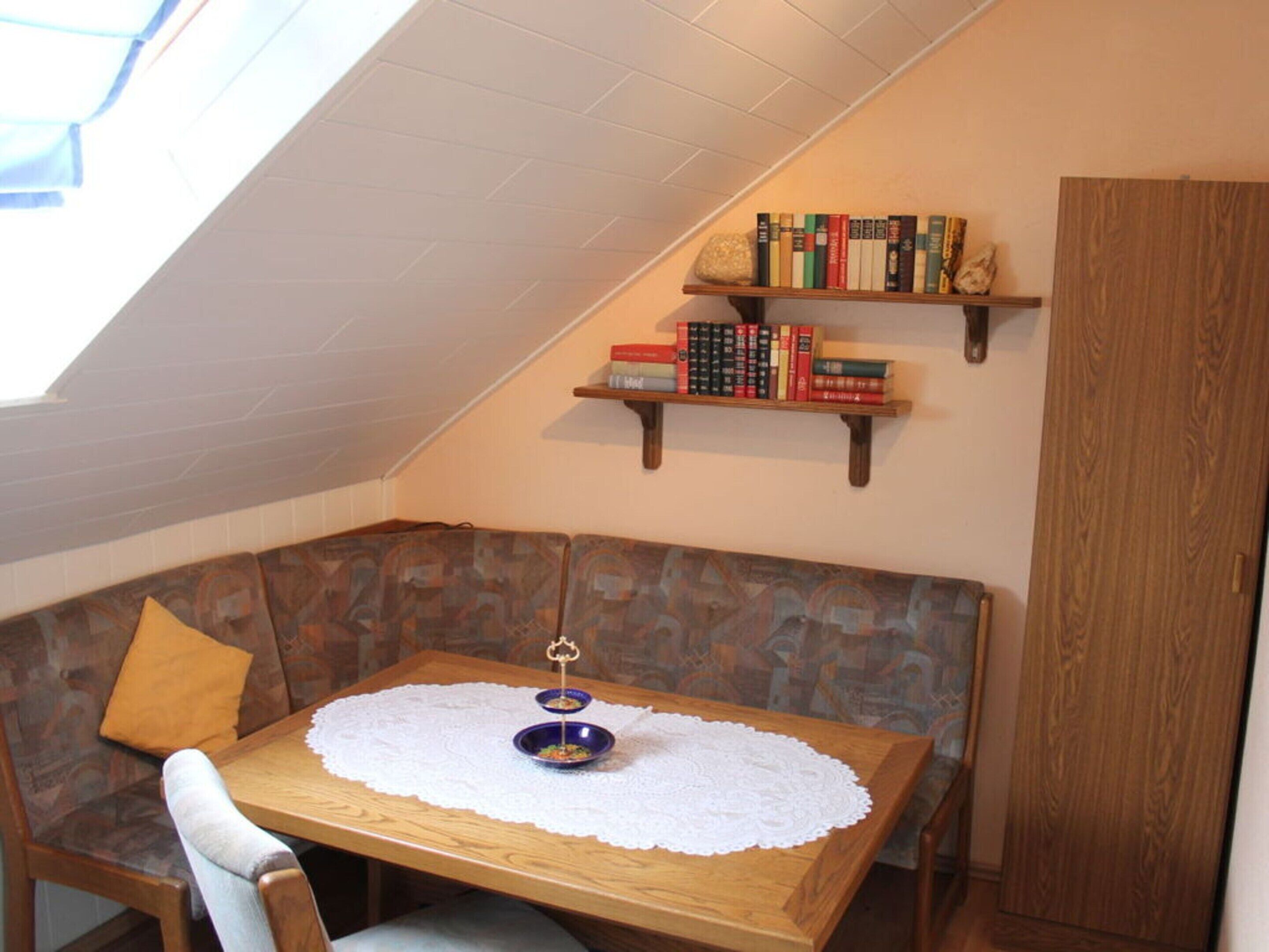 Un coin accueillant avec une table en bois, un banc et une bibliothèque.