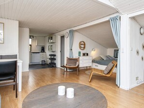 Ein kompakter Wohnbereich mit Essbereich, Küchenzeile und einem Schlafzimmer mit Bett und Sitzecke.