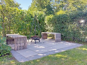 An outdoor patio area with a fire pit, wooden benches, and a hanging chair. - 6 Person Holiday Home in Hemmet (Hemmet)