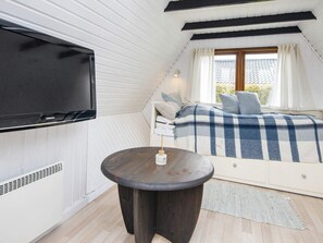 A bedroom with a bed, a TV mounted on the wall, and a small round table. - 6 Person Holiday Home in Hemmet (Hemmet)