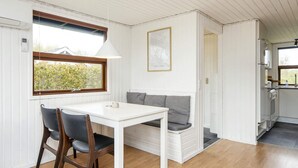 Et kompakt køkken med spiseplads, et vindue med udsigt og en indbygget bænk.