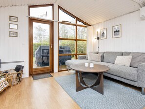 A cozy living room with a grey sofa, a round coffee table, and a wicker basket. - 6 Person Holiday Home in Hemmet (Hemmet)
